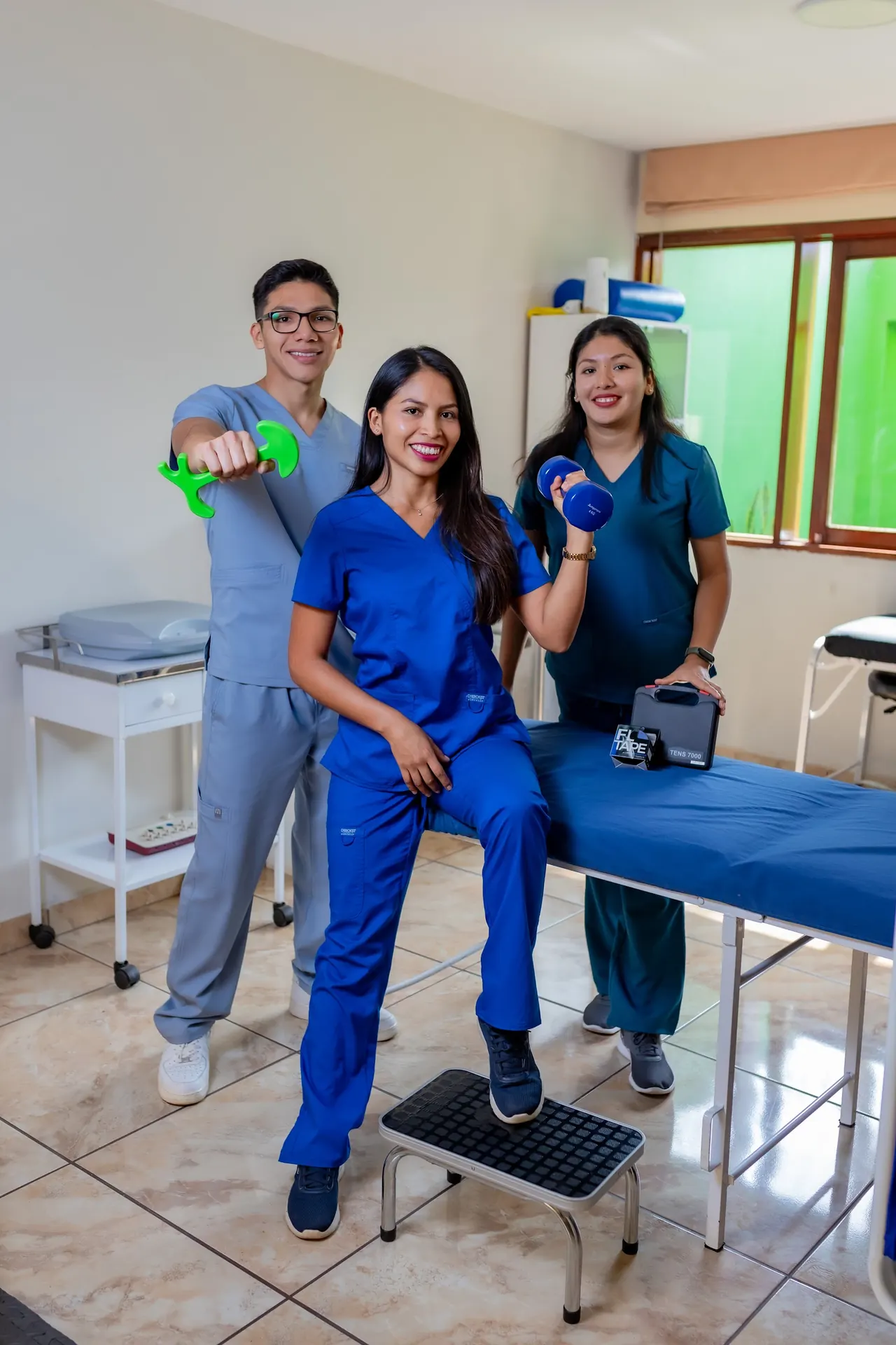 El equipo de Kinevital en el consultorio, con pesas en la mano junto a una camilla